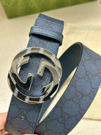Gucci belt with dark blue textured strap and large silver interlocking G buckle
