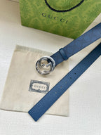 Gucci belt flat lay with dark blue strap and silver interlocking G buckle close-up