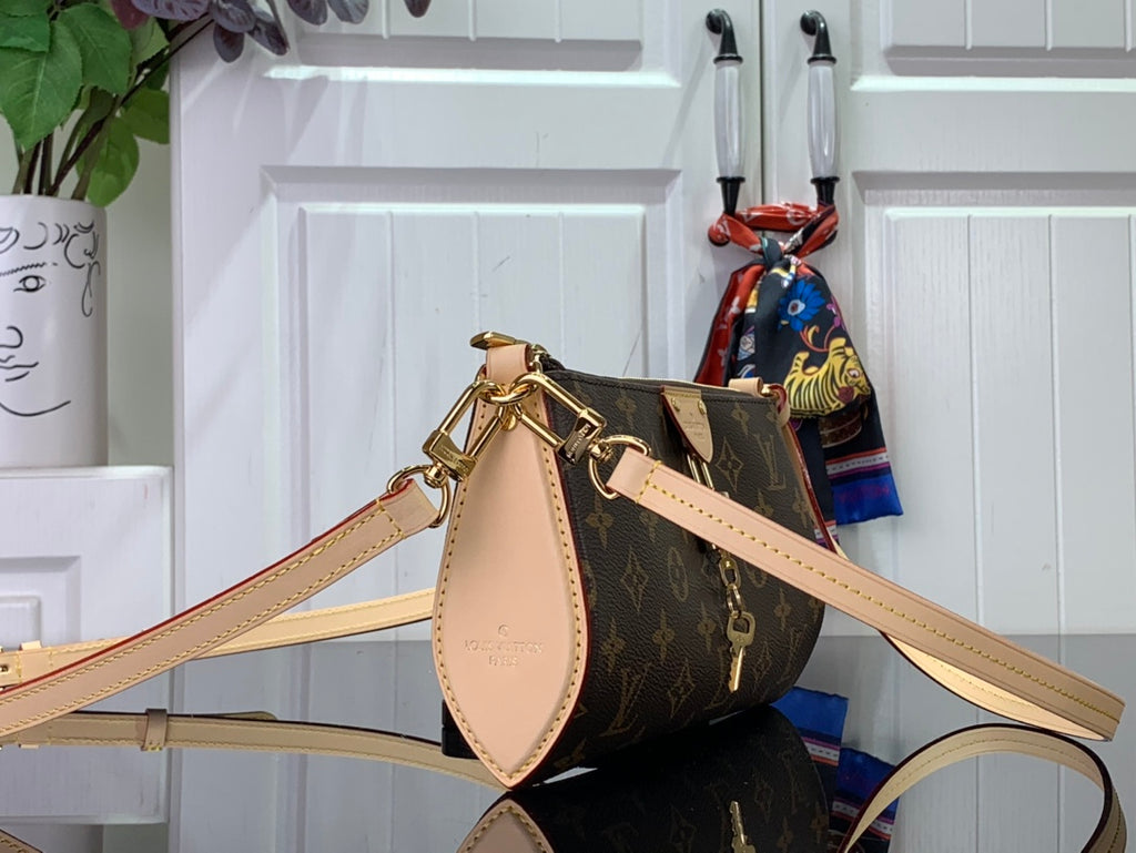 Louis Vuitton monogram crossbody bag with tan shoulder strap and gold clasp detail
