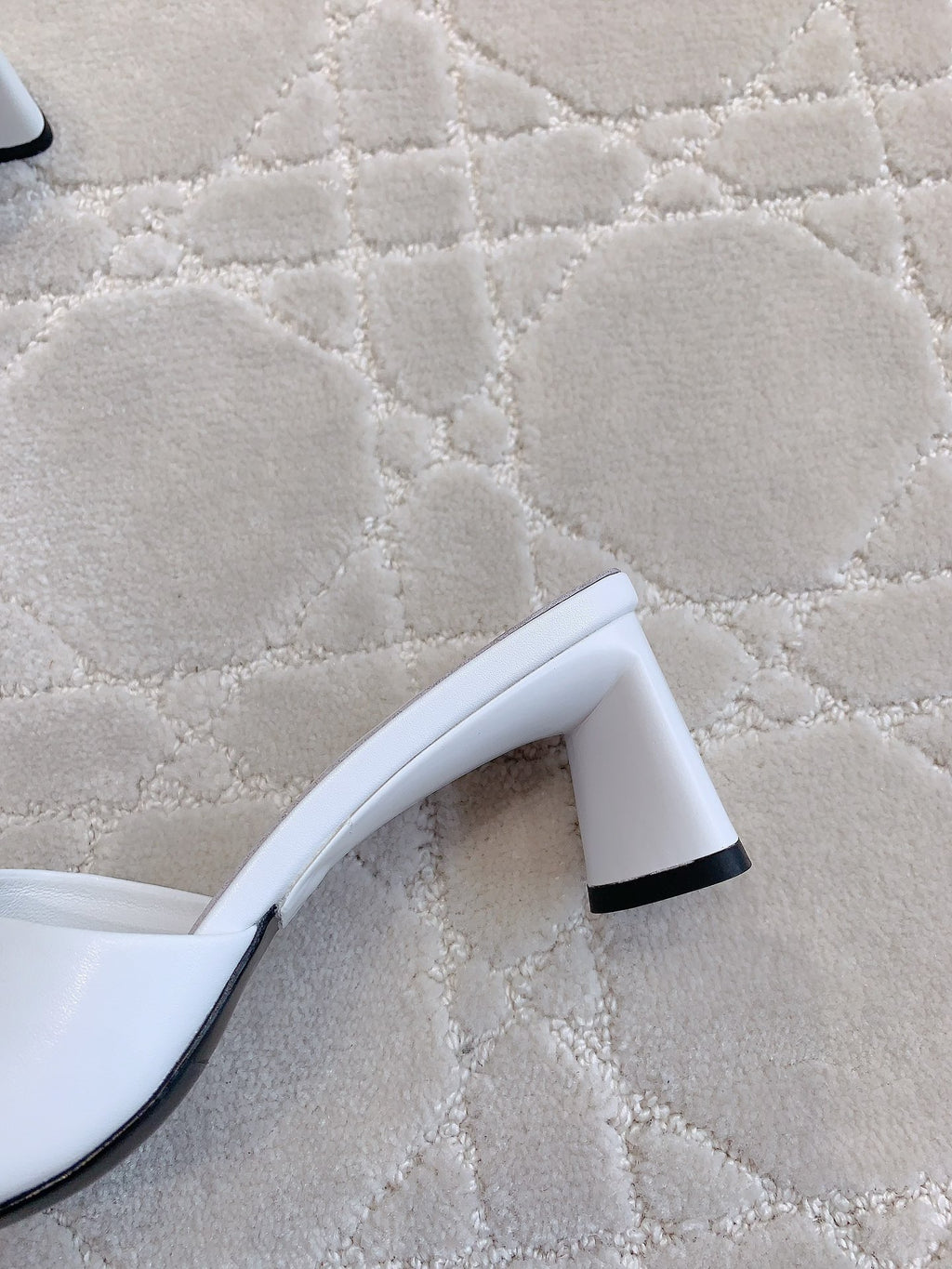 Balenciaga white sandals showing black heel detail and curved sole