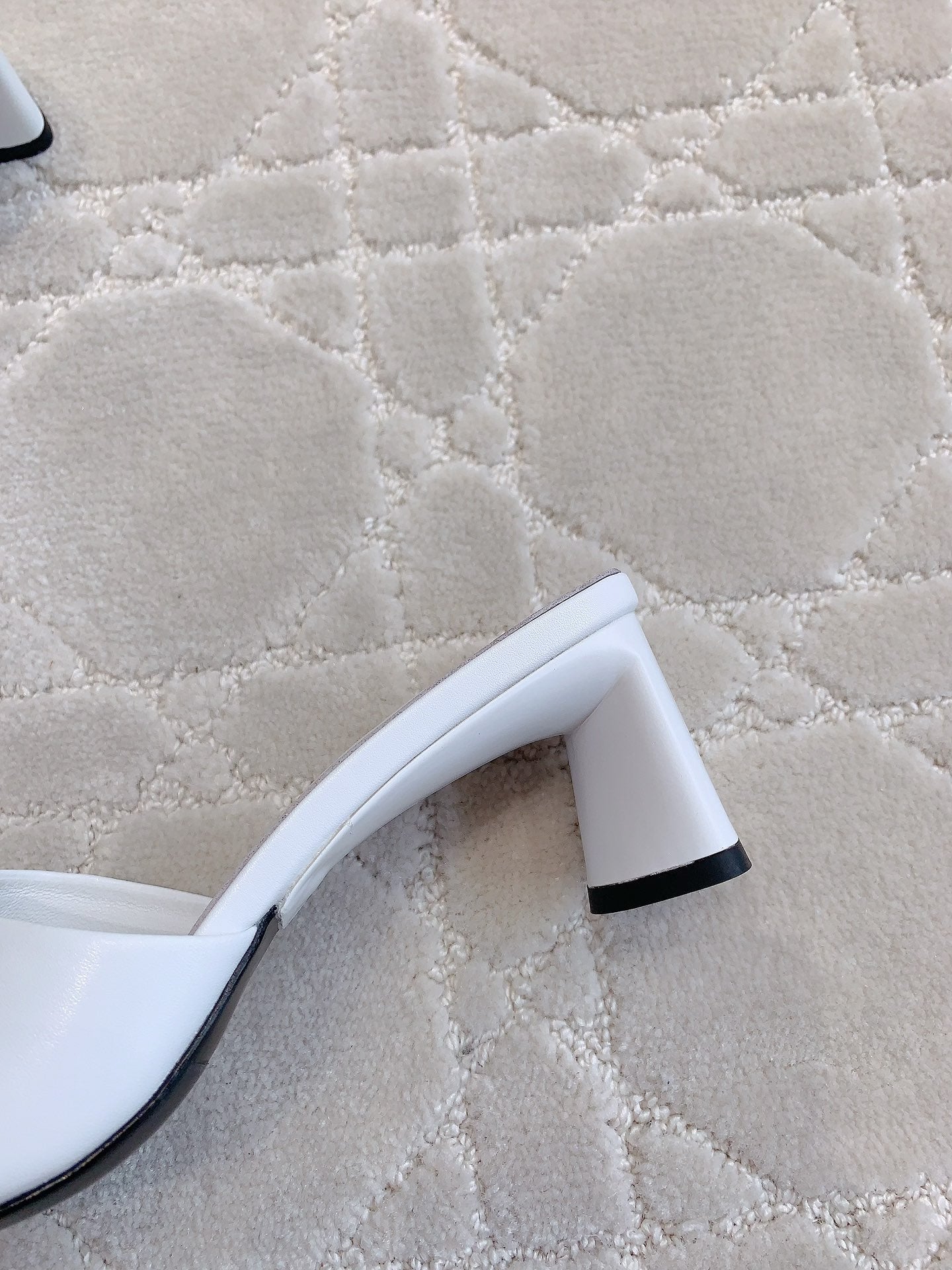 Balenciaga white sandals showing black heel detail and curved sole