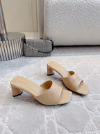 Beige slide sandals with thick block heel and wide strap, side view