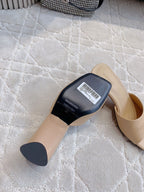 Beige slide sandal with black underside label and barcode tag, angled