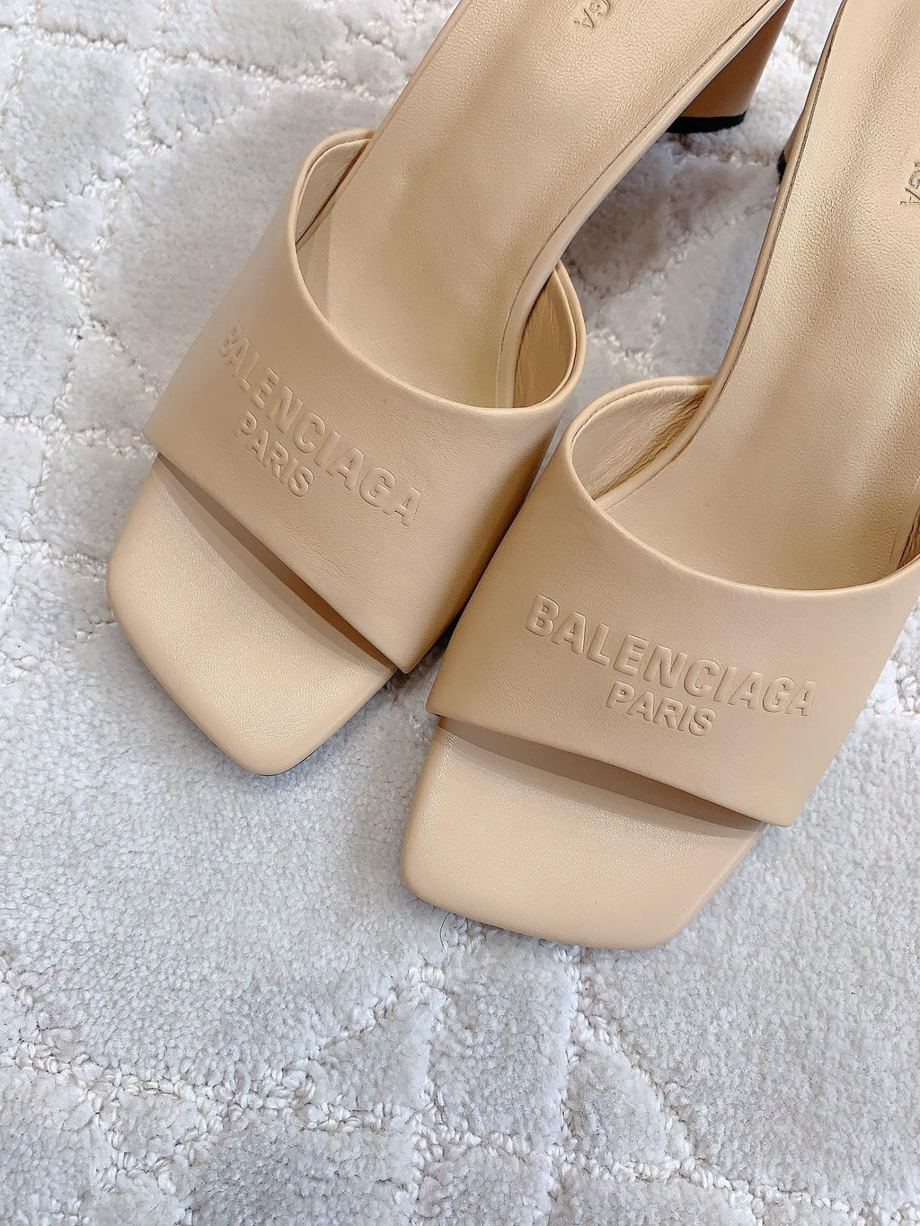 Beige slide sandals with BALENCIAGA logo on strap, close-up