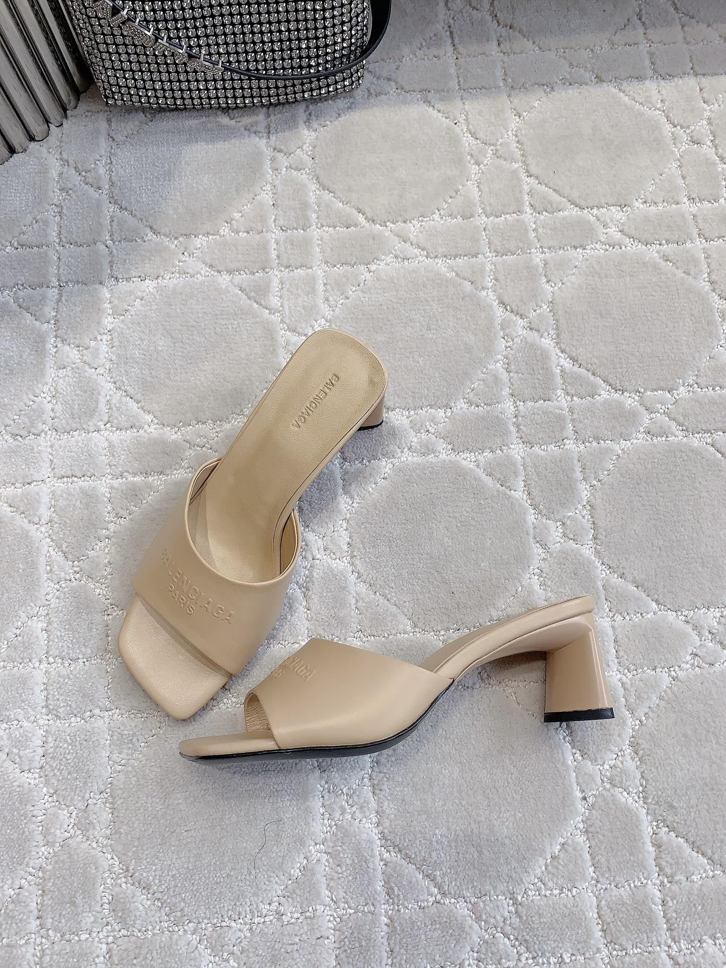 Beige slide sandal with wide strap and block heel, angled side view
