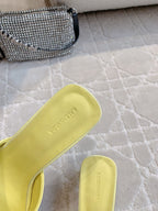 Yellow sandal with open back and footbed logo text