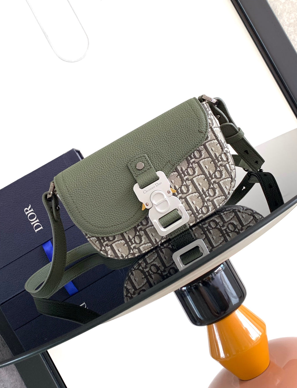 Green flap crossbody bag with beige monogram canvas and silver buckle hardware