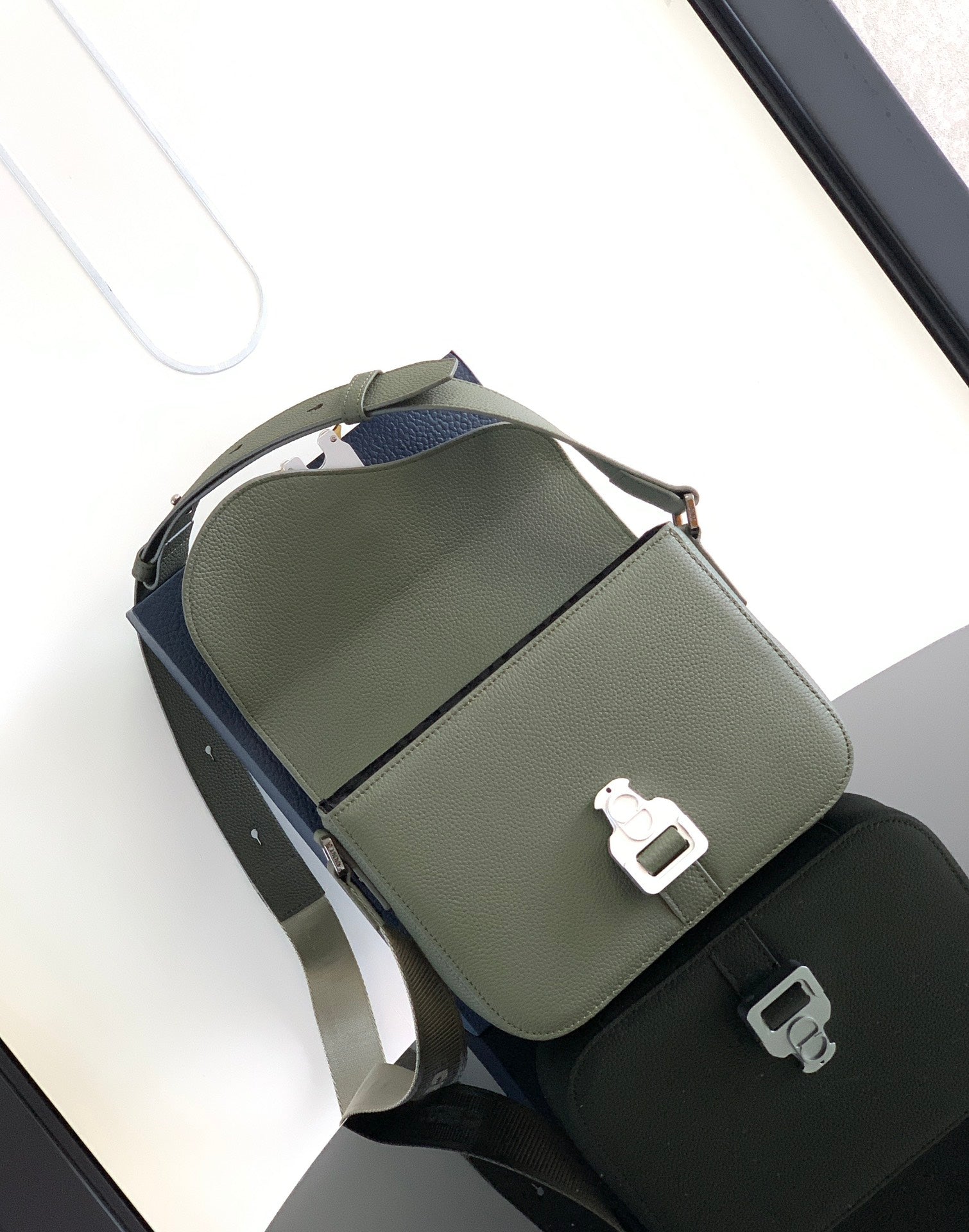 Sage green leather crossbody bag with top handle strap and front buckle hardware