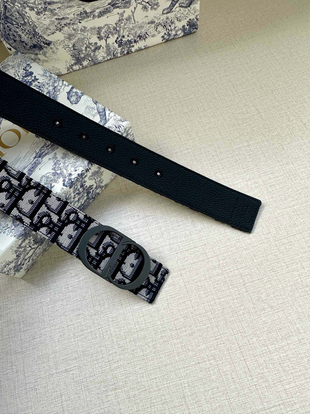 Dior monogram belt with navy patterned strap and dark leather buckle strap with holes