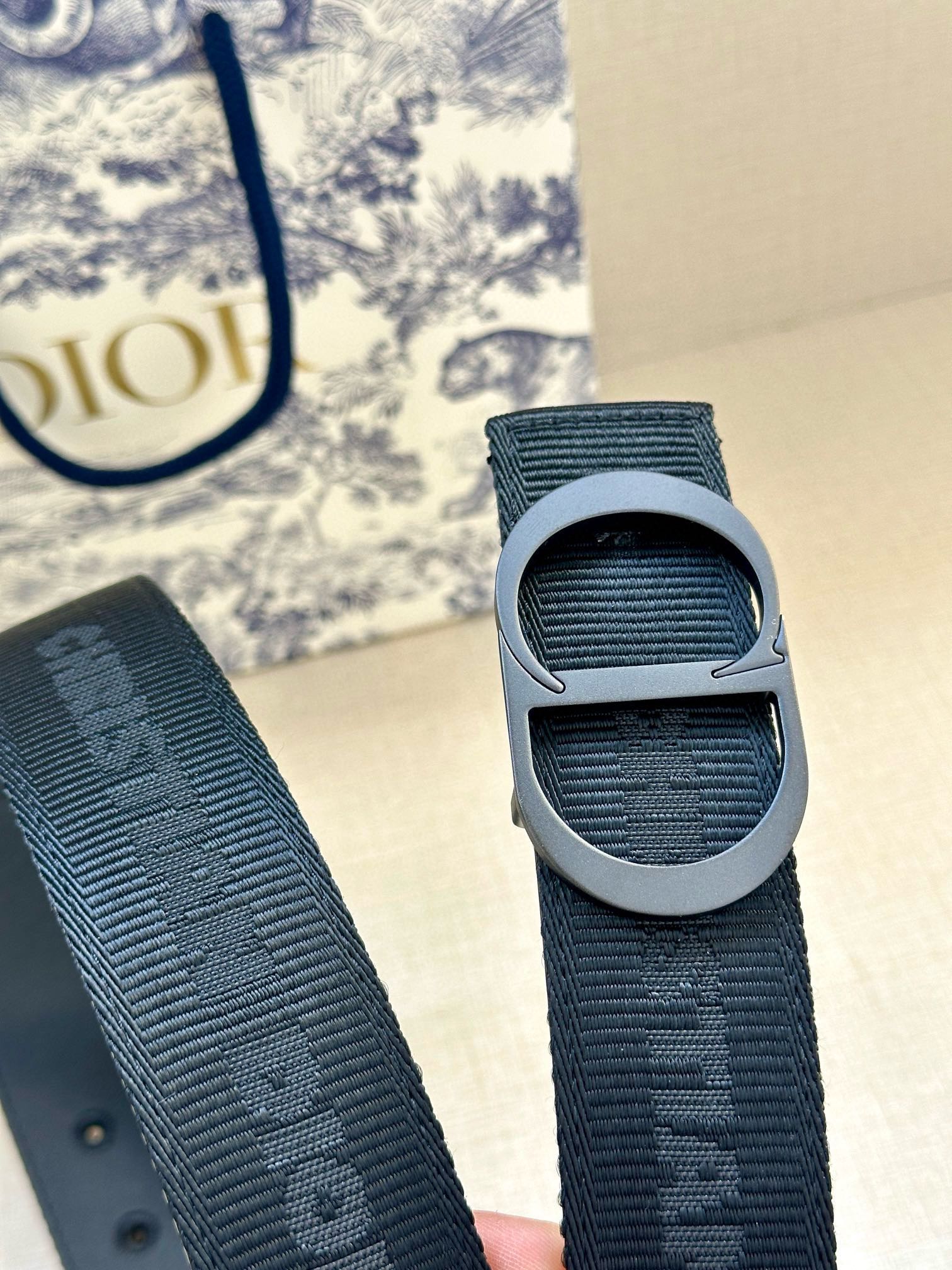 Dark blue belt strap detail with gray buckle and textured woven design