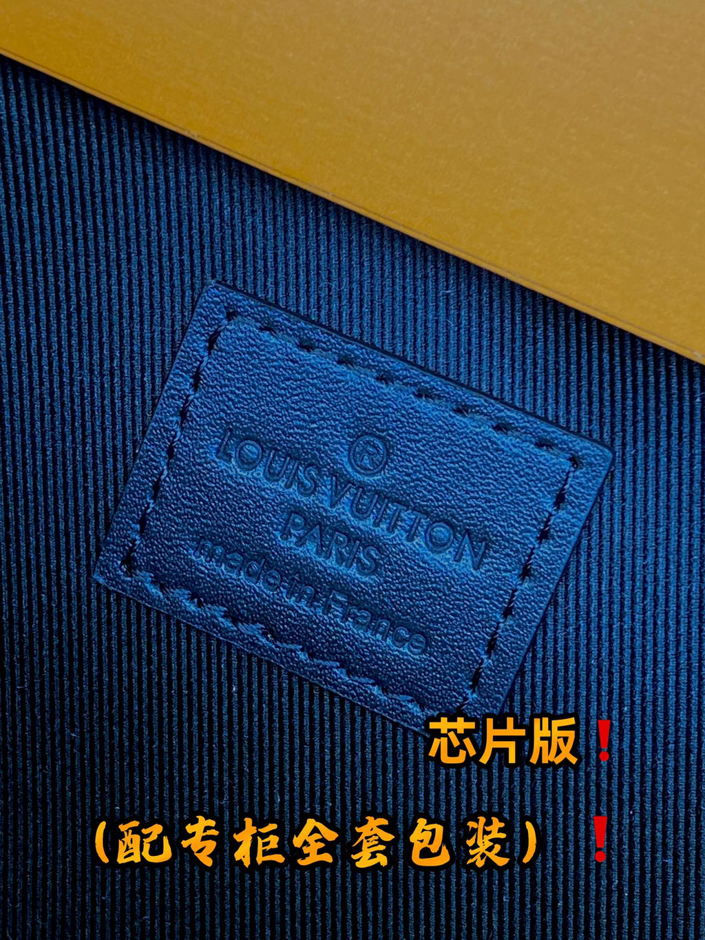 Louis Vuitton logo leather tag stitched on dark fabric