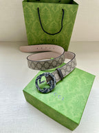 Gucci belt with beige GG canvas, black-and-green patterned buckle, pink underside