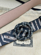 Gucci belt close-up with navy-and-white monogram strap and circular interlocking buckle
