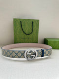 Gucci belt with GG canvas strap, blue edge stitching, and circular logo buckle.