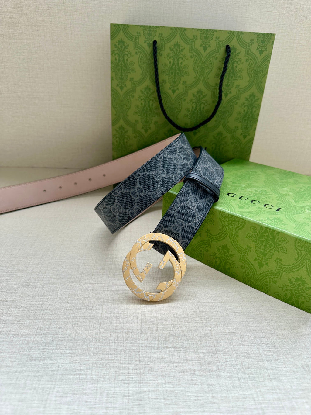 Gucci belt with dark blue GG strap and gold-toned circular buckle