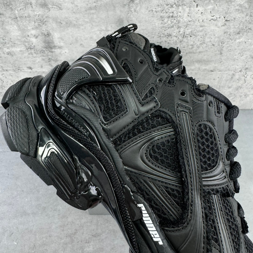 Balenciaga unisex black sneaker quarter view, metallic logo detail, lace-up upper