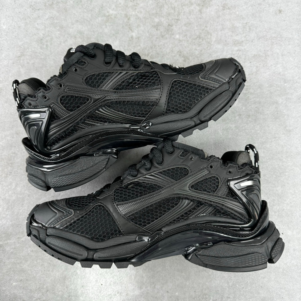 Balenciaga unisex black running-style sneakers, front 3/4 view, lace-up pair with logos