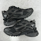 Balenciaga unisex black running-style sneakers, front 3/4 view, lace-up pair with logos