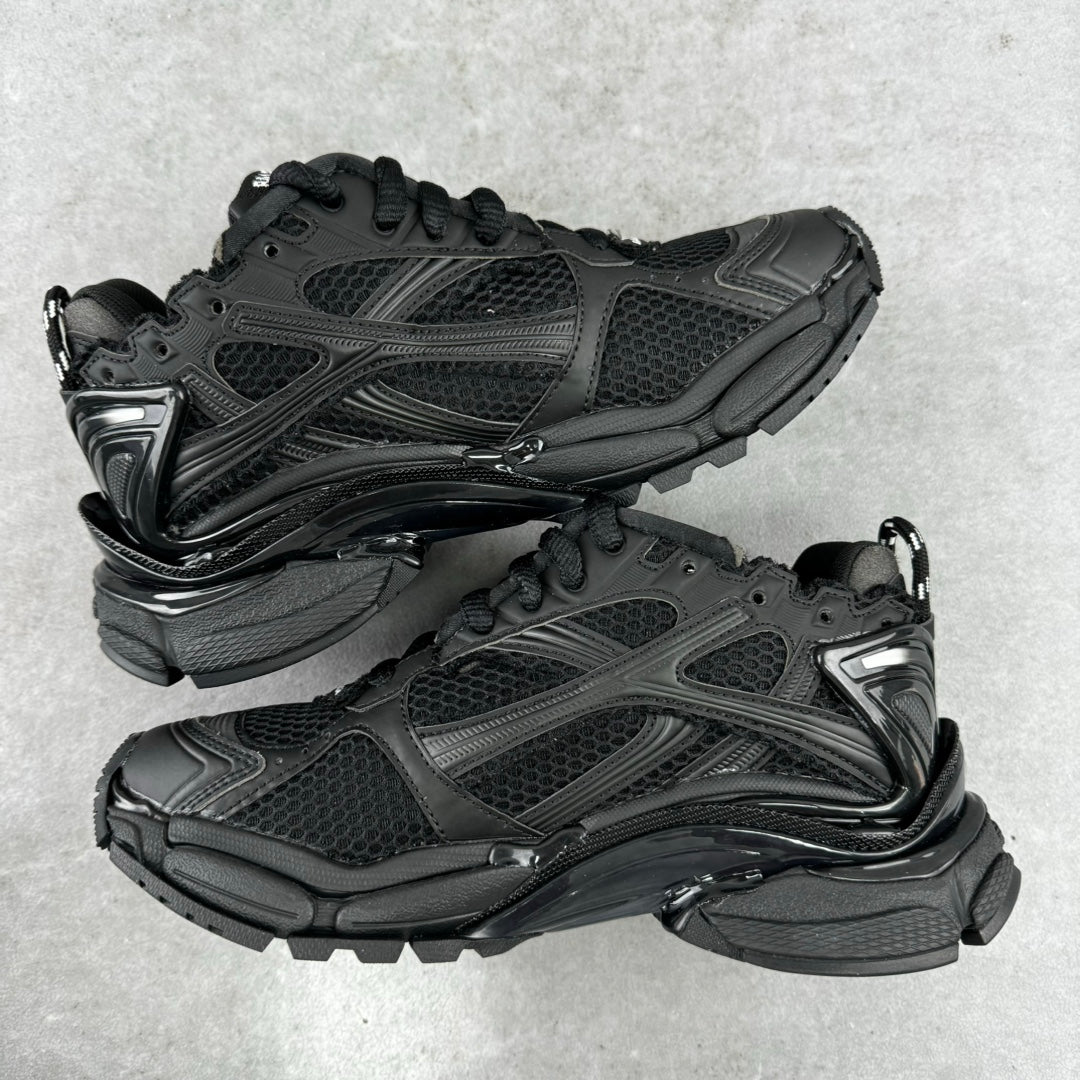 Balenciaga unisex black running-style sneakers, front 3/4 view, lace-up pair with logos