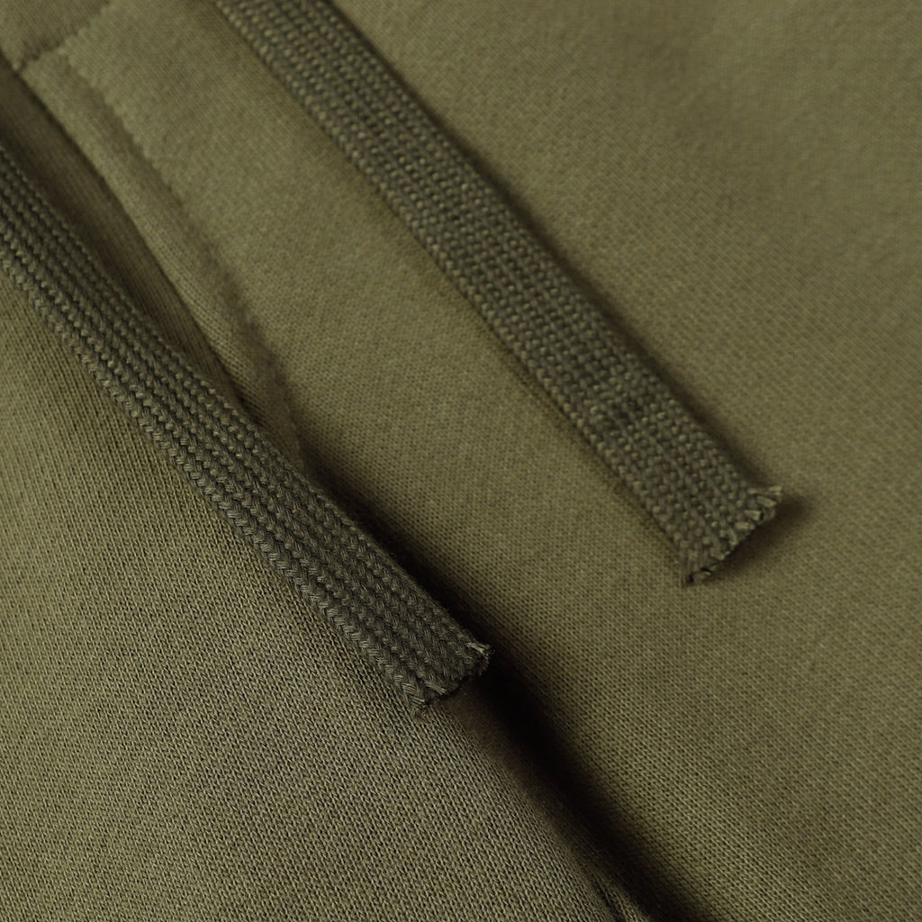 Olive fabric close-up showing drawstring seam and stitched hem