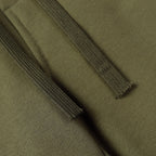 Olive fabric close-up showing drawstring seam and stitched hem