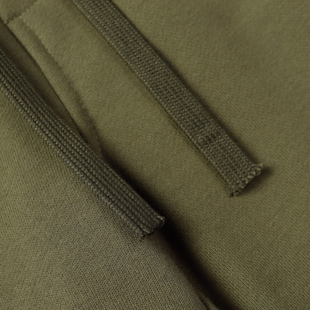Olive fabric close-up showing drawstring seam and stitched hem