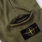 Olive shorts detail showing black inner lining and Stone Island logo patch