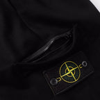 Black shorts with concealed zipper opening and logo patch on pocket