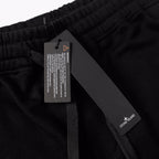 Black shorts with internal drawstring and hanging tag at waistband