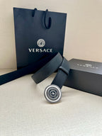 Dark blue leather belt with round silver logo buckle