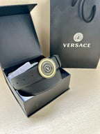 Dark blue leather belt with gold circular logo buckle in box