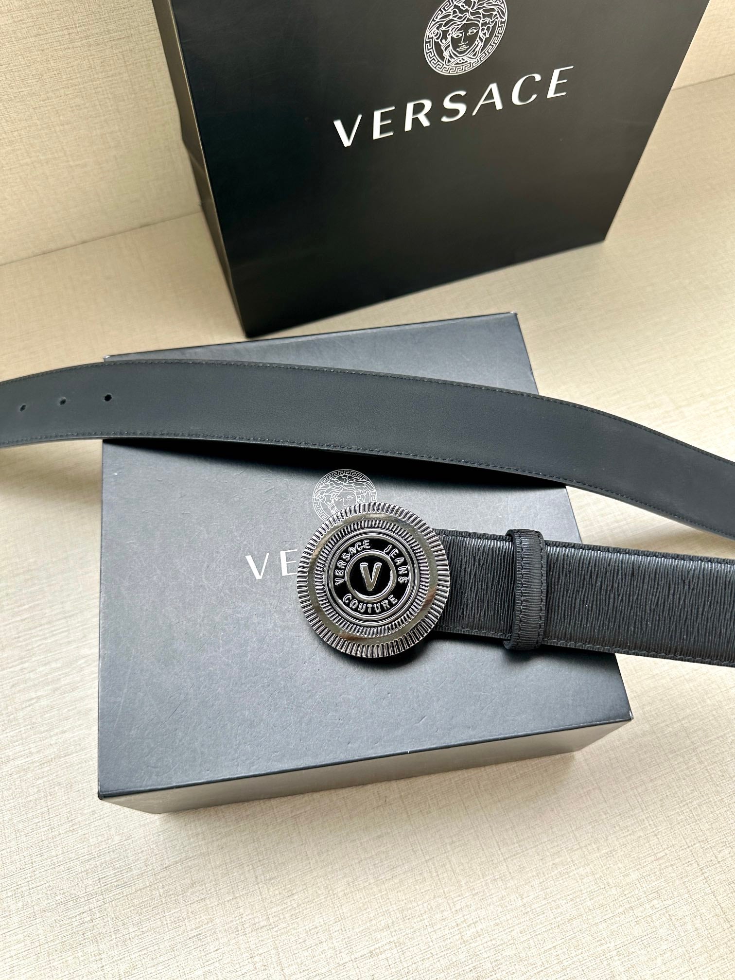 Dark blue leather belt with circular silver buckle detail