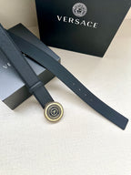 Dark blue leather belt with gold circular logo buckle
