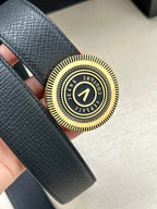Versace belt buckle close-up with circular gold-tone crest on dark blue leather