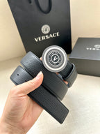 Versace belt held in hand: dark blue leather with round gold-tone logo buckle