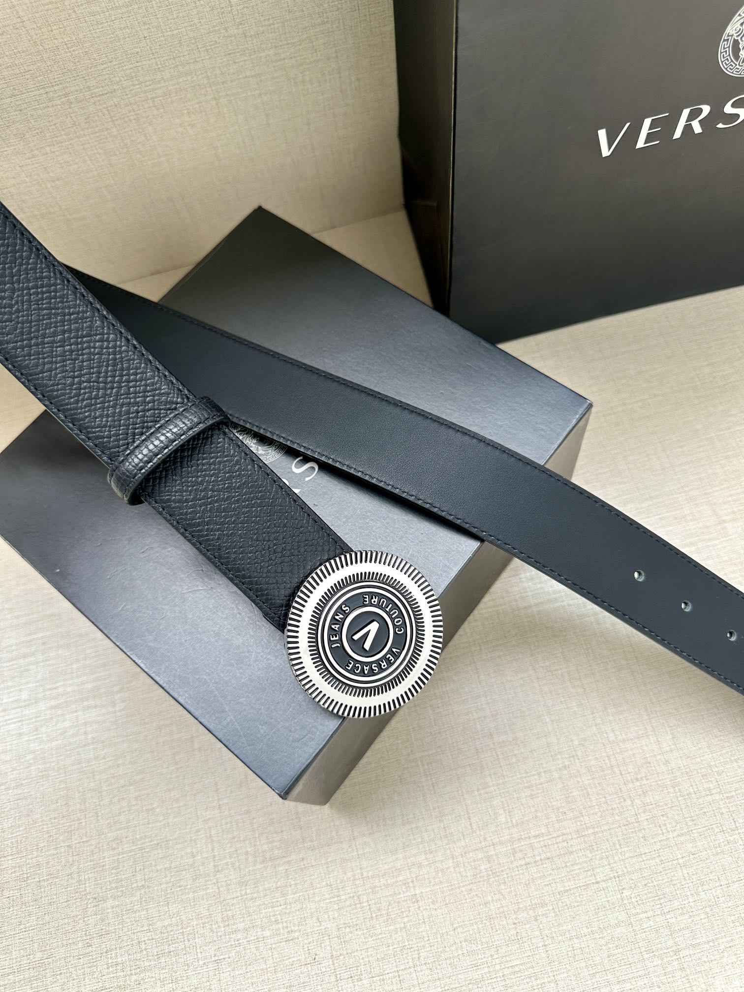 Versace belt side view: dark blue leather strap with circular gold-tone buckle