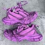 Pink Balenciaga sneakers with black stripe accents, chunky soles, and lace-up uppers