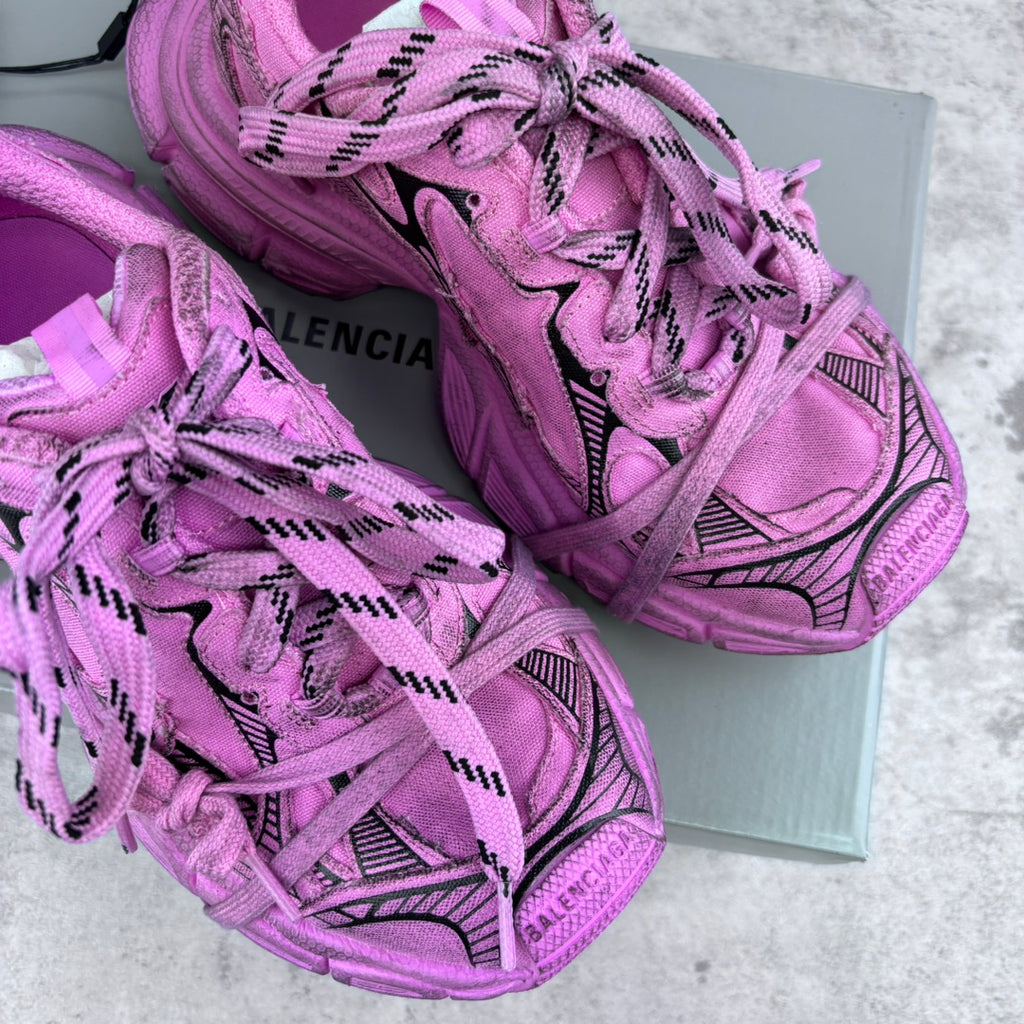 Pink Balenciaga sneakers on box, lace-up design with black accents and stitched details