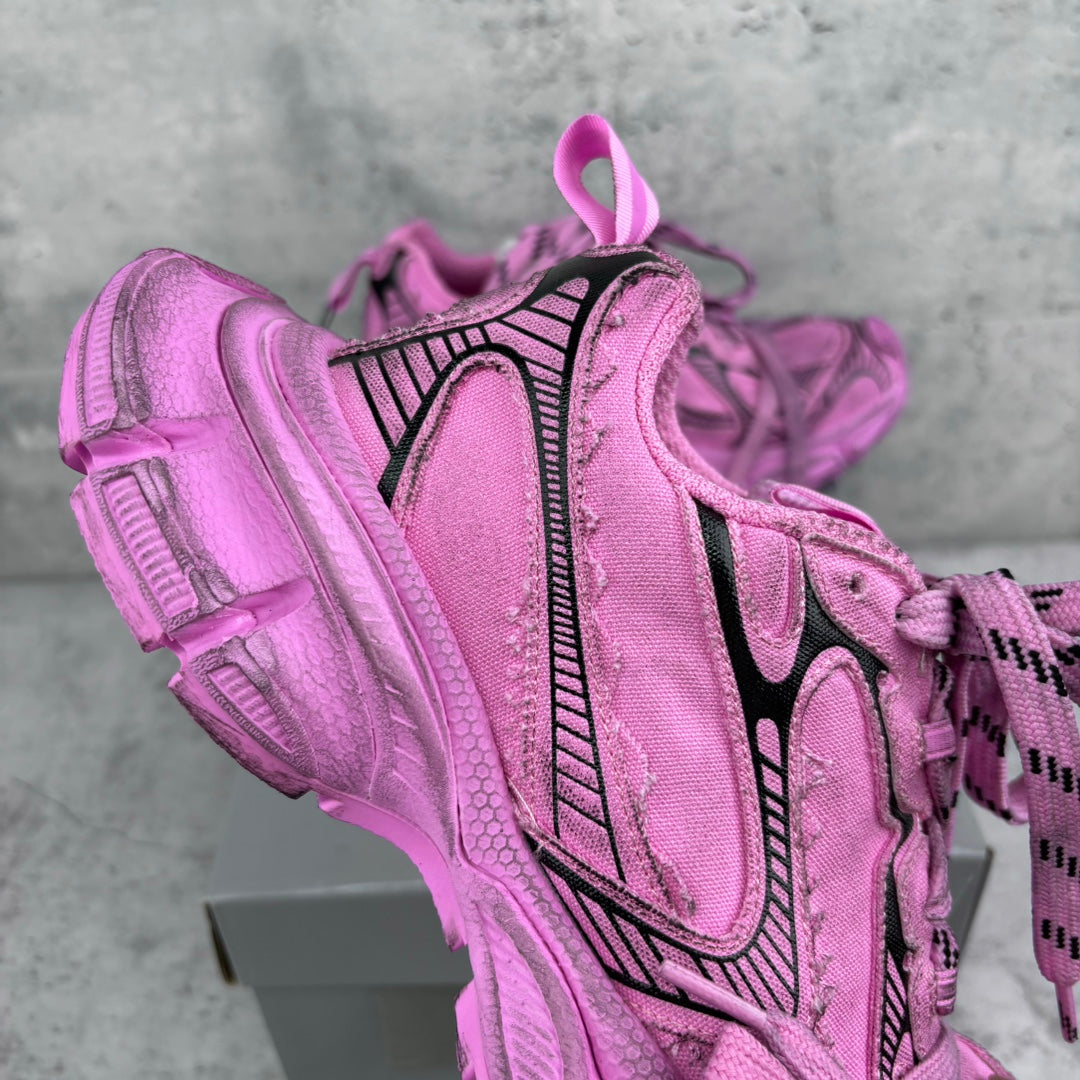 Pink Balenciaga sneaker with black logo stripe, textured paneling, and lace-up closure