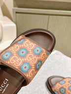 Close-up of brown slide sandals showing multicolor patterned strap and interior branding