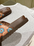 Side view of brown slide sandal with multicolor patterned strap and cushioned footbed