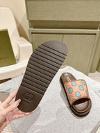 Outsole view of brown slide sandals with multicolor patterned strap