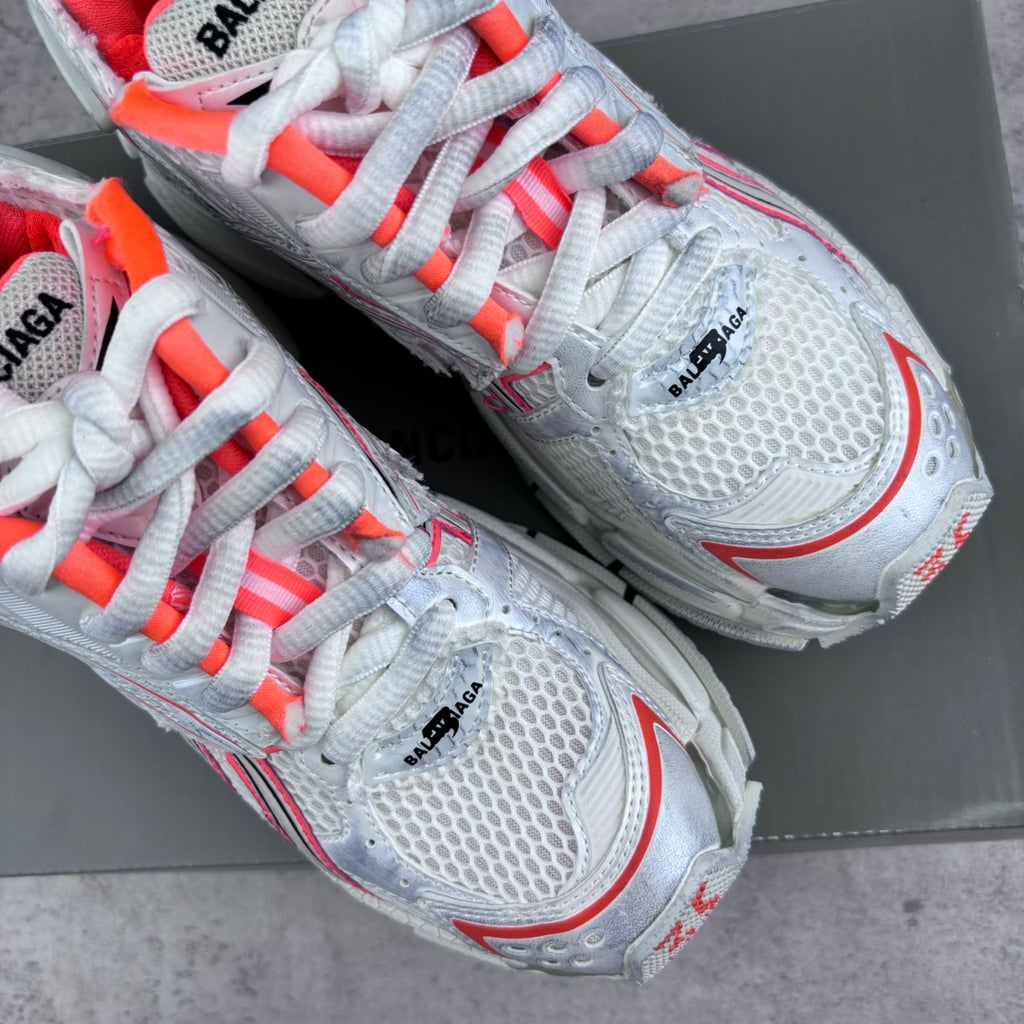 Unisex sneakers with white laces, mesh panels, and red accent logo on the side