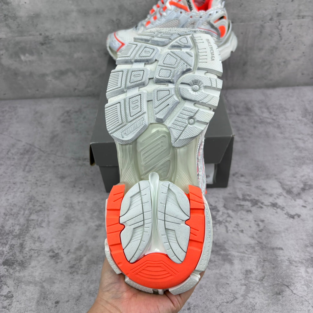 Unisex sneaker outsole view with white tread and orange-red heel section