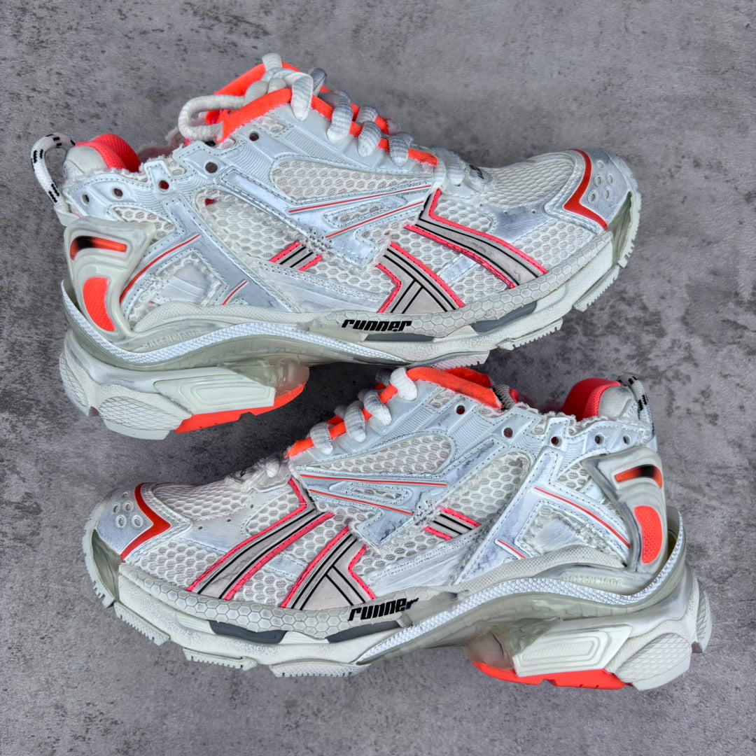 Unisex sneakers with white mesh uppers, red trim, chunky gray soles, and orange laces