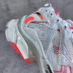 Unisex sneaker side view with white upper, red accent details, and thick midsole