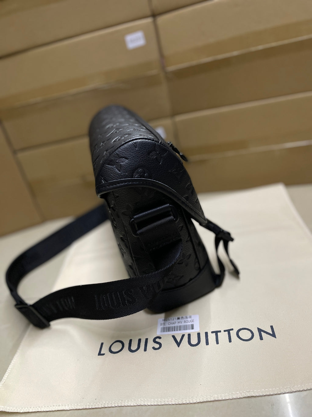 Louis Vuitton men's messenger bag strap and flap detail in dark monogram leather