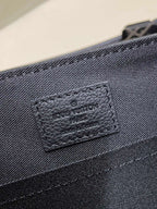 Louis Vuitton men's bag leather label with stamped logo on dark monogram