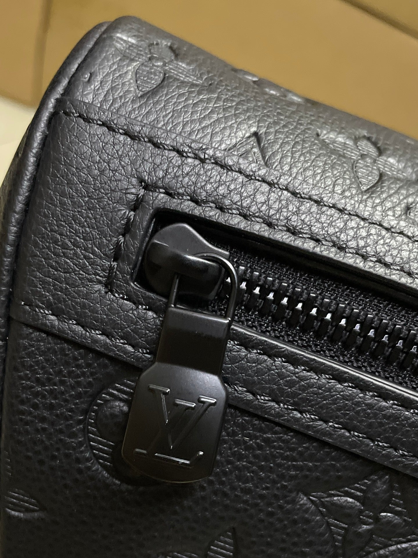 Black textured leather bag with zip pull and Louis Vuitton Paris stamp