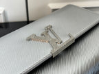 Louis Vuitton silver-gray bag close-up of metallic LV logo on textured flap